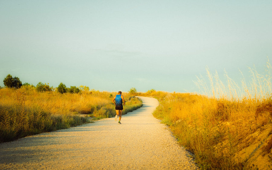 Runner on a sunlit path through golden fields, supplements for daily energy