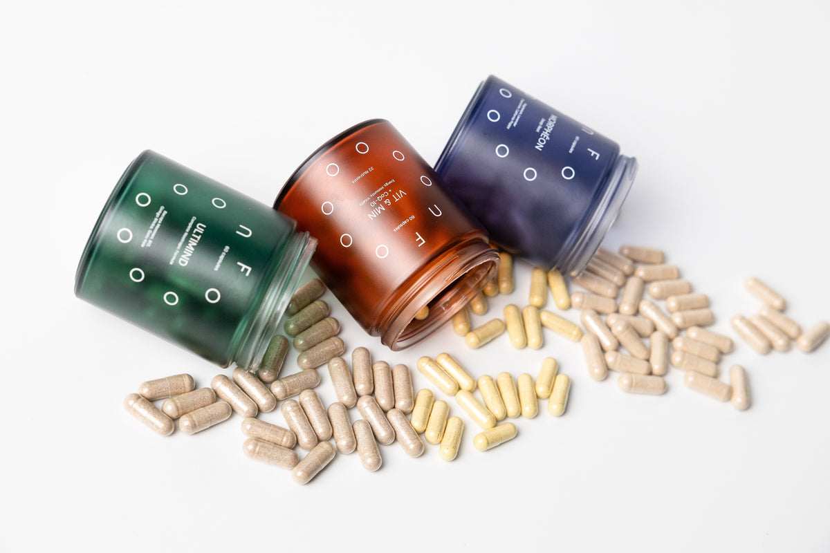 FOOON Ultimind, VIT & MIN + CoQ10 and Morphéon liposomal supplement jars tipped over with capsules spilling onto a white surface