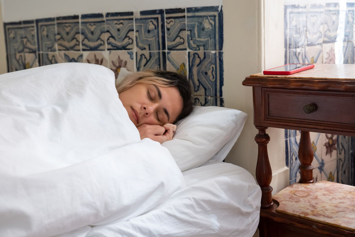 Woman sleeping soundly in bed, long term melatonin use and safety