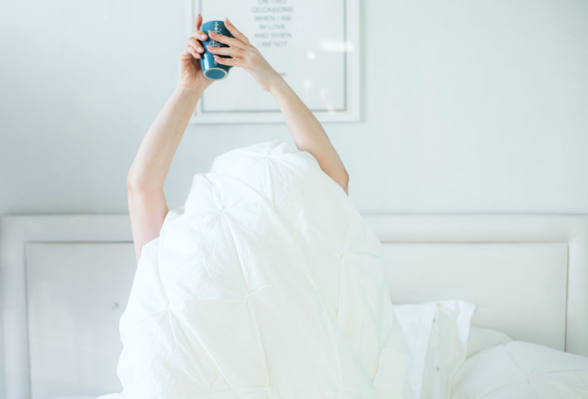 Relaxed morning in bed with a cup of coffee, supplements built for real life