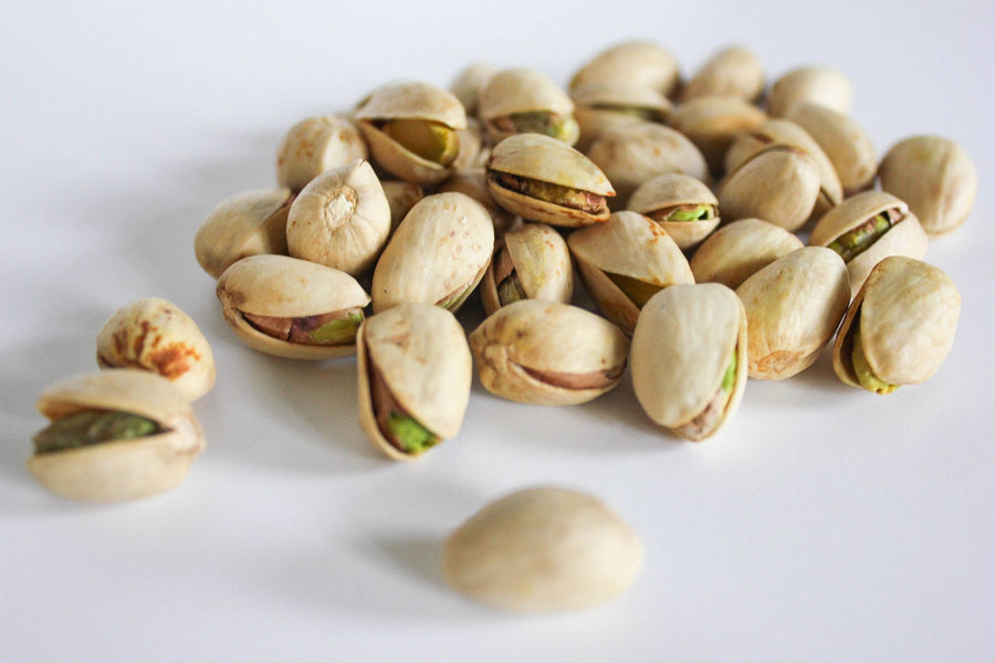 Pistachios on a white surface, a natural source of zinc for sleep and recovery
